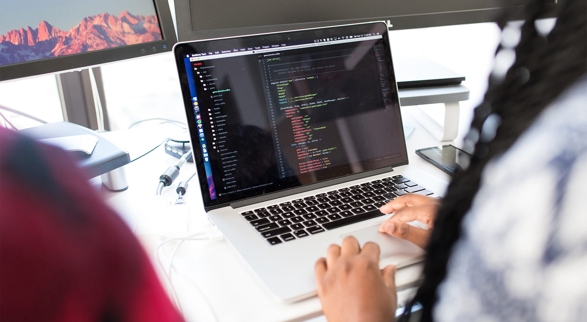 Två personer står vid en bärbar dator.