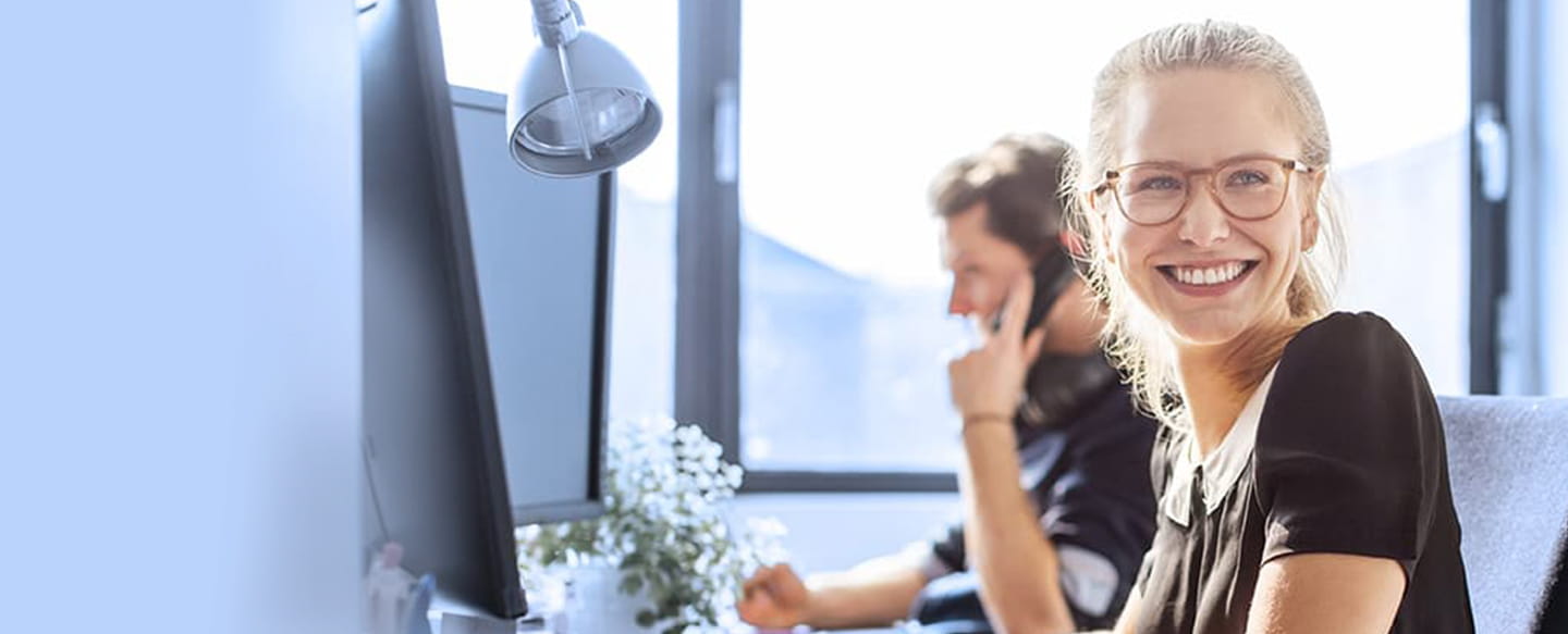 Glad tjej framför datorn - Javautbildning med Experis Academy