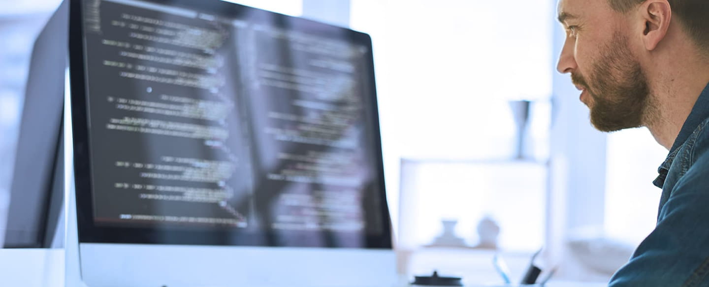 Programmerare framför skärm med kod